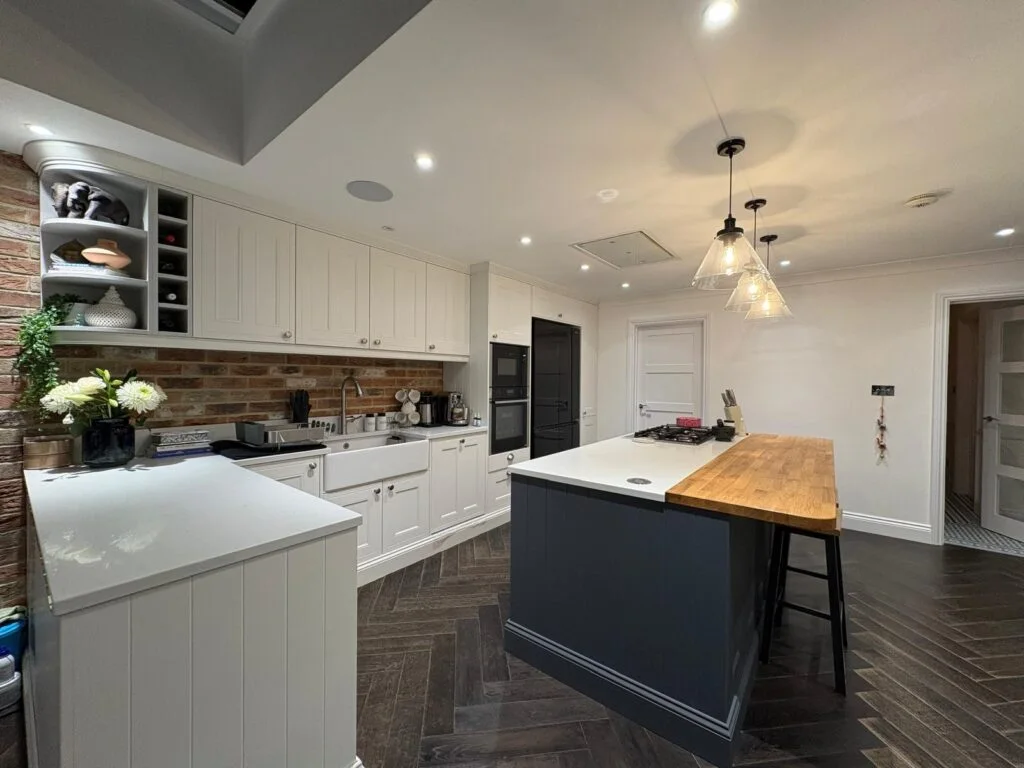 White fitted kitchen with a dark island and timber breakfast bar from Matthew 633's gallery
